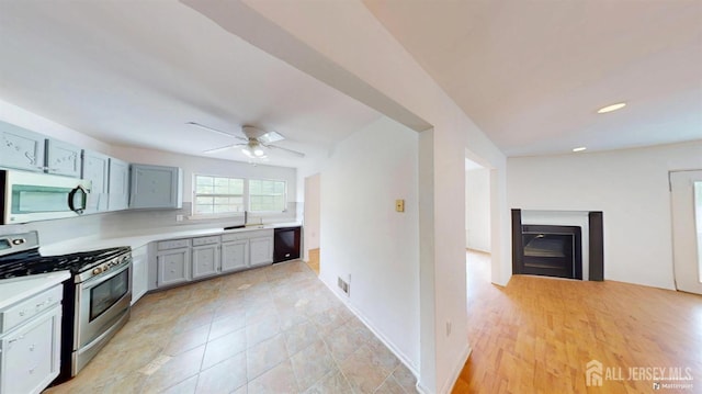 28 Elm St, East Brunswick, NJ 08816 - kitchen with appliances with stainless steel finishes, light countertops, ceiling fan, and a fireplace