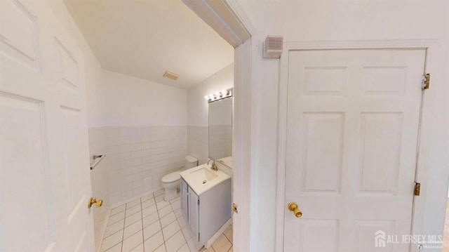 28 Elm St, East Brunswick, NJ 08816 - bathroom featuring tile patterned flooring, tile walls, vanity, and a wainscoted wall