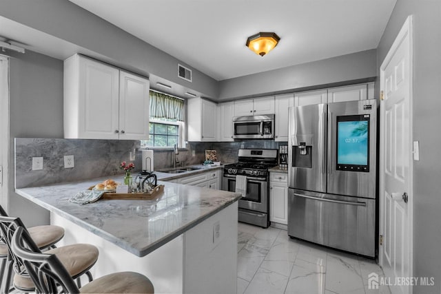 41 Haymarket Ct, East Windsor, NJ 08512 - kitchen with stainless steel appliances, a peninsula, light marble finish floors, light stone counters, and white cabinetry