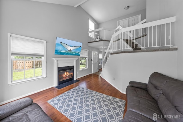 41 Haymarket Ct, East Windsor, NJ 08512 - living room featuring stairs, a fireplace with flush hearth, high vaulted ceiling, and wood finished floors