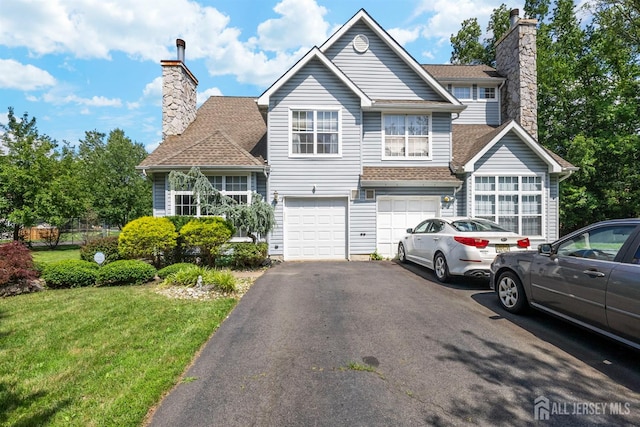 41 Haymarket Ct, East Windsor, NJ 08512 - view of front facade featuring a chimney, an attached garage, asphalt driveway, and a front lawn