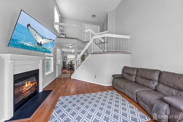 41 Haymarket Ct, East Windsor, NJ 08512 - living area featuring stairs, wood finished floors, a glass covered fireplace, and a towering ceiling