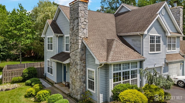 41 Haymarket Ct, East Windsor, NJ 08512 - view of front facade featuring a chimney, roof with shingles, an attached garage, and driveway