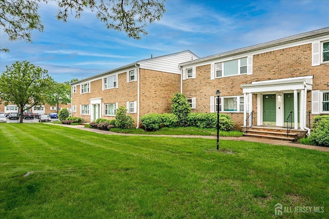 view of front of property with a front lawn and brick siding