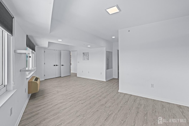110 Somerset St Unit 2114, New Brunswick, NJ 08901 - unfurnished living room with recessed lighting, light wood finished floors, baseboards, and a wall mounted AC