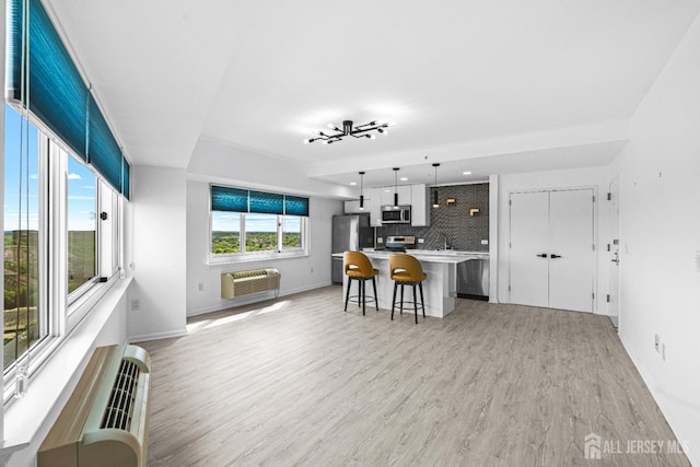 110 Somerset St Unit 2114, New Brunswick, NJ 08901 - kitchen with appliances with stainless steel finishes, an AC wall unit, light wood-style flooring, decorative backsplash, and a breakfast bar area