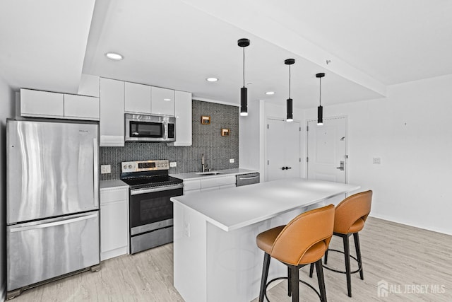 110 Somerset St Unit 2114, New Brunswick, NJ 08901 - kitchen with appliances with stainless steel finishes, a sink, white cabinets, a kitchen island, and light wood-style flooring