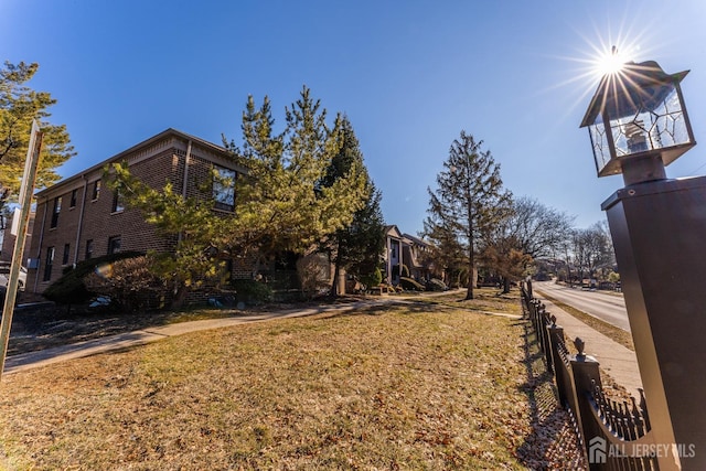 view of home's exterior with brick siding and a lawn