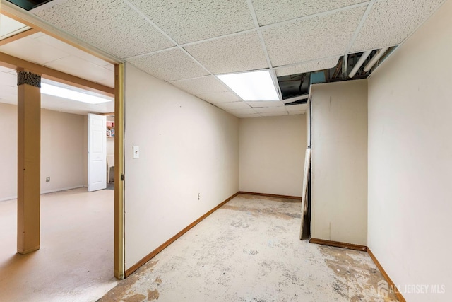 finished basement with a drop ceiling and baseboards