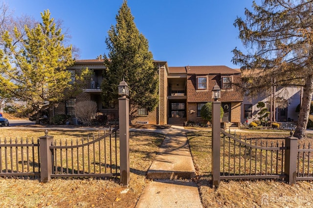view of front of home with brick siding and fence