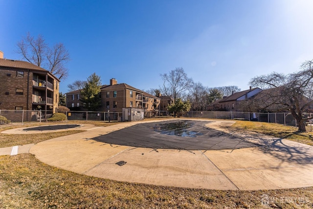 community pool with a patio area, a residential view, and fence