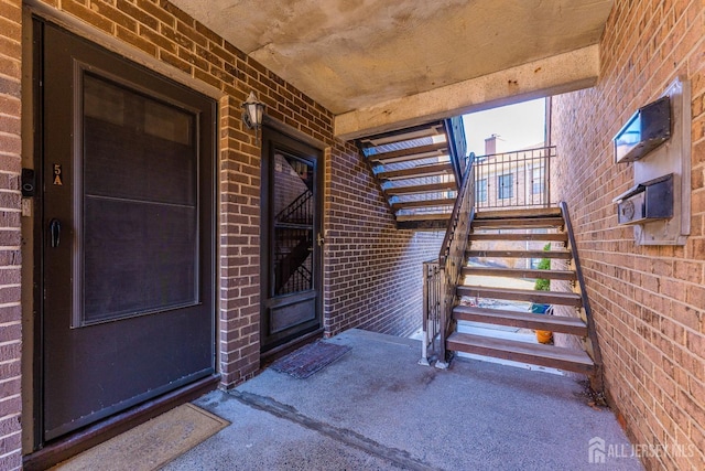 doorway to property featuring brick siding and a porch