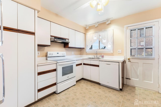 kitchen featuring white appliances, light countertops, white cabinets, and a sink