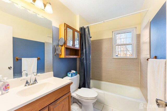 bathroom featuring shower / tub combo with curtain, vanity, toilet, and tile patterned floors