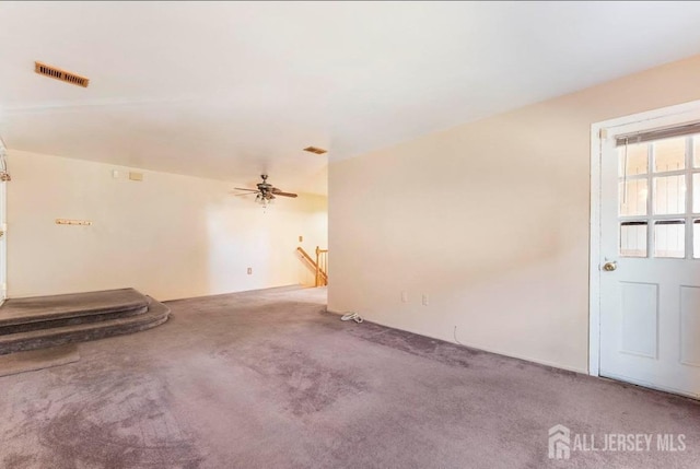 unfurnished living room with carpet, visible vents, and ceiling fan
