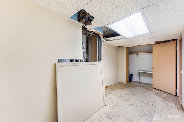 finished below grade area featuring a drop ceiling