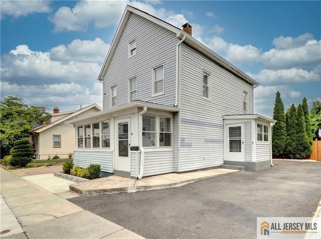 15 Leland Ave, South River, NJ 08882 - view of front of house with a chimney, a sunroom, and a patio