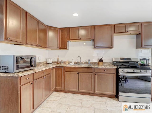 15 Leland Ave, South River, NJ 08882 - kitchen featuring appliances with stainless steel finishes, light stone countertops, and brown cabinets