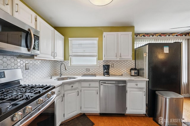 816 Harbortown Blvd Unit 816, Perth Amboy, NJ 08861 - kitchen with stainless steel appliances, light wood-style flooring, white cabinets, and decorative backsplash