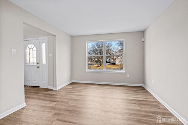 entrance foyer featuring baseboards and wood finished floors