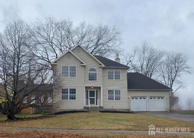 view of front of property featuring a garage and a front lawn