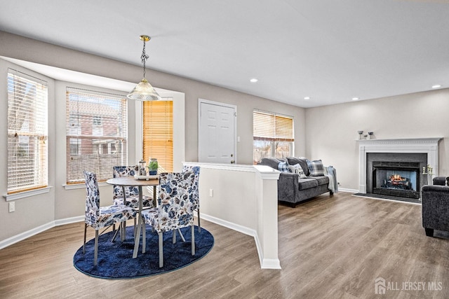 dining area featuring baseboards, plenty of natural light, and wood finished floors