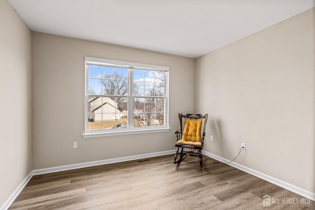 living area featuring baseboards and wood finished floors