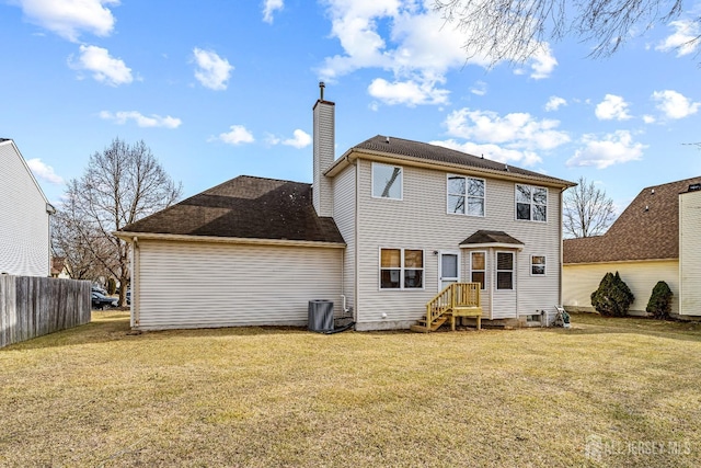 back of house with a lawn, a chimney, and fence