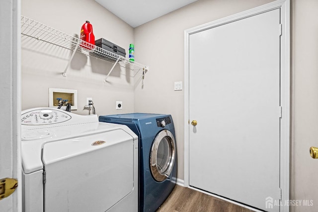 laundry area featuring washer and dryer, wood finished floors, and laundry area