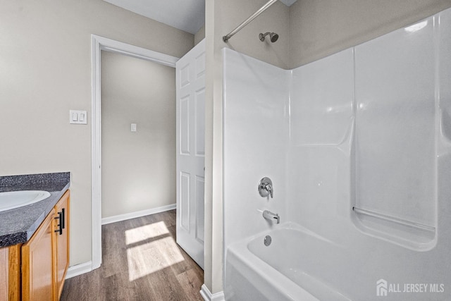 full bathroom featuring vanity, wood finished floors, baseboards, and shower / bathtub combination