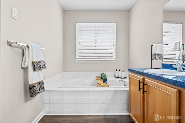 bathroom featuring vanity, a garden tub, and wood finished floors