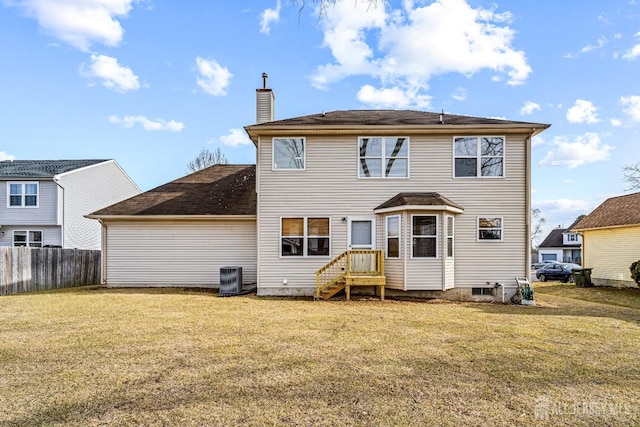 rear view of house with a yard, central AC unit, a chimney, and fence