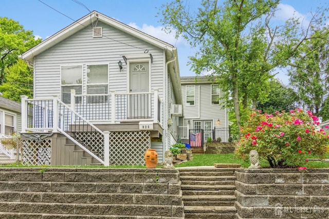 shotgun-style home with stairway, a wooden deck, and fence