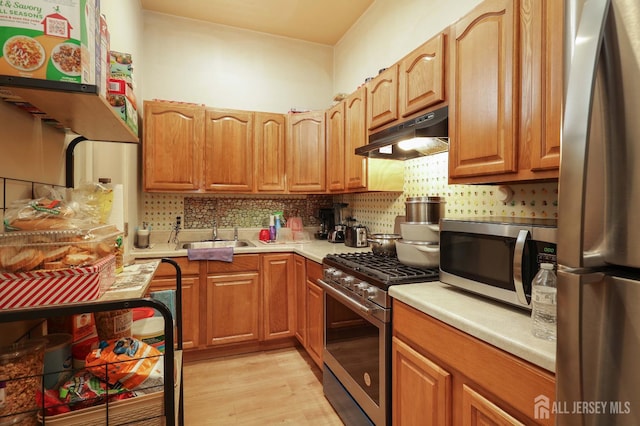 440 Bruck Ave, Perth Amboy, NJ 08861 - kitchen with appliances with stainless steel finishes, under cabinet range hood, light countertops, light wood finished floors, and backsplash