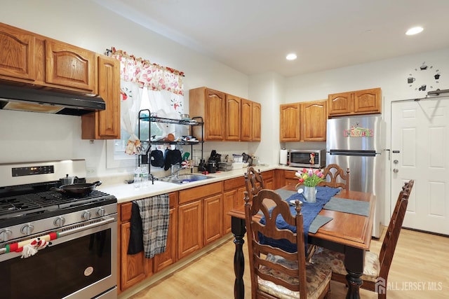 440 Bruck Ave, Perth Amboy, NJ 08861 - kitchen featuring stainless steel appliances, under cabinet range hood, light wood-style floors, brown cabinetry, and recessed lighting