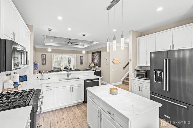 6 Traditions Pl, Monroe, NJ 08831 - kitchen featuring appliances with stainless steel finishes, crown molding, a tray ceiling, light wood-style floors, and recessed lighting