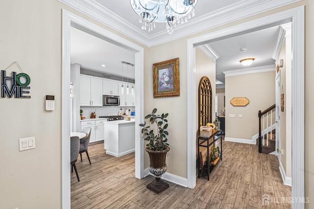 6 Traditions Pl, Monroe, NJ 08831 - hall featuring stairs, light wood-style floors, a chandelier, and ornamental molding