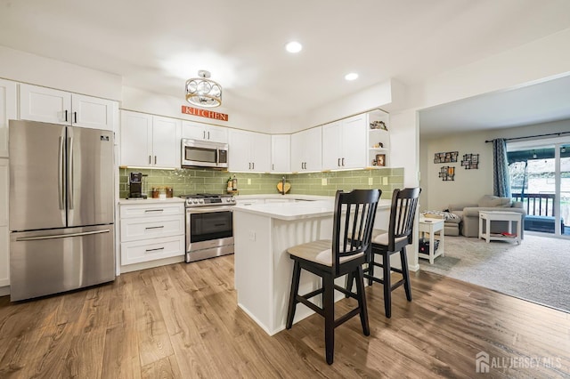 30 Forest Garden Dr, Old Bridge, NJ 07747 - kitchen featuring stainless steel appliances, open shelves, light countertops, white cabinetry, and a kitchen bar