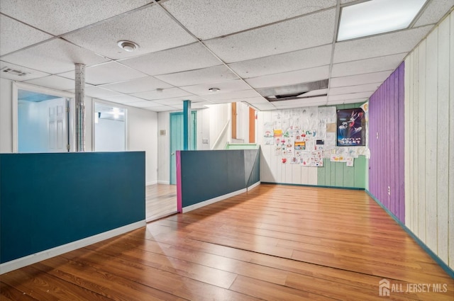 9 Merion Dr, Manalapan, NJ 07726 - empty room with wood finished floors, a paneled ceiling, baseboards, and wood walls