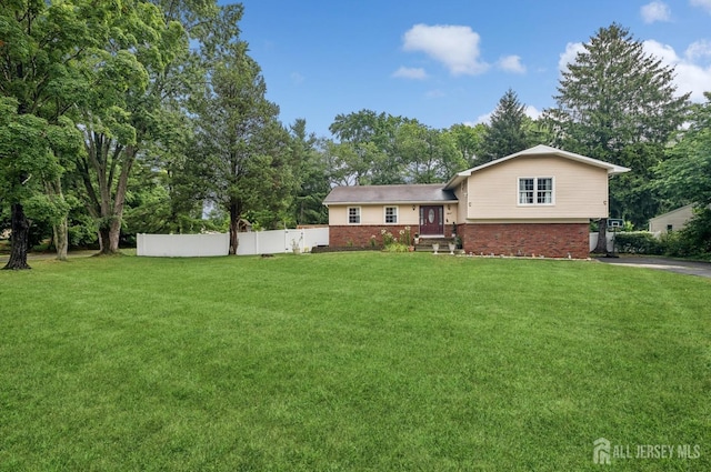 9 Merion Dr, Manalapan, NJ 07726 - split level home with brick siding, driveway, view of scattered trees, and a garage
