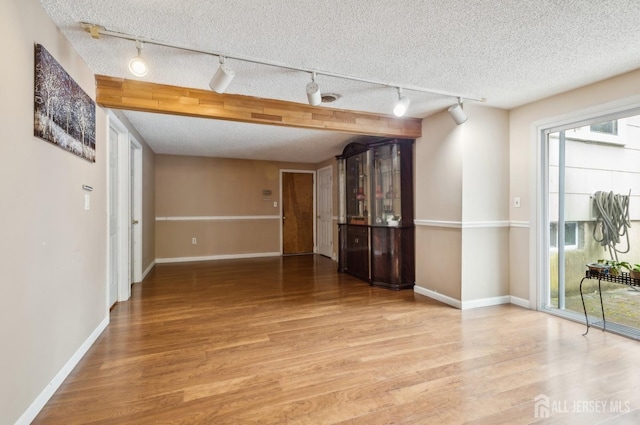 9 Merion Dr, Manalapan, NJ 07726 - empty room featuring track lighting, wood finished floors, baseboards, and a textured ceiling