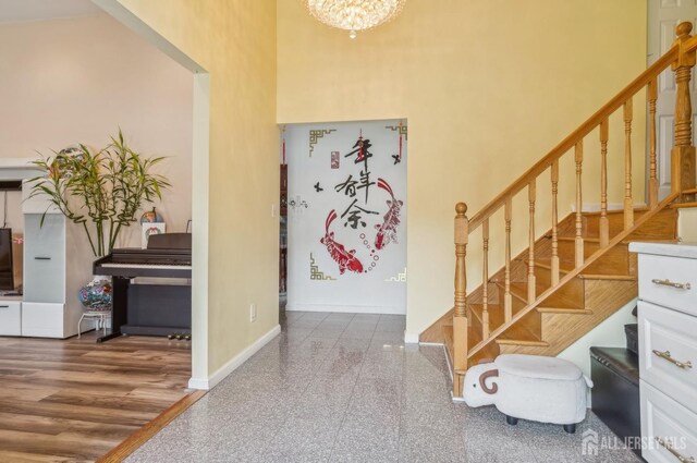 9 Merion Dr, Manalapan, NJ 07726 - entryway featuring stairway, a high ceiling, a chandelier, baseboards, and granite floors