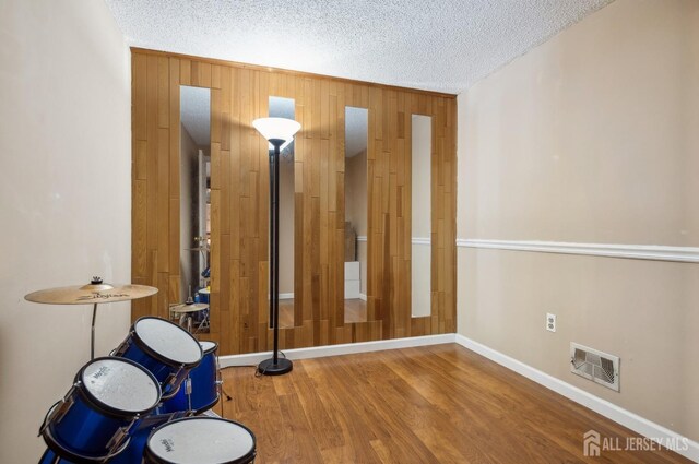 9 Merion Dr, Manalapan, NJ 07726 - spare room with wood finished floors, a textured ceiling, baseboards, and wood walls
