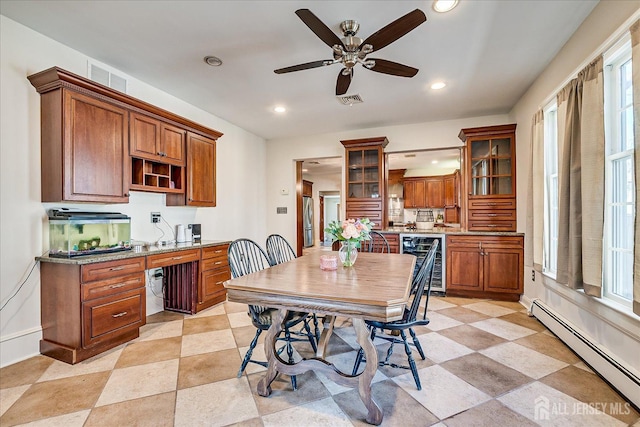 dining area with a baseboard radiator, wine cooler, visible vents, and built in study area