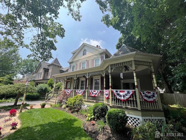 view of front facade featuring a porch and fence