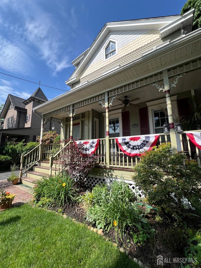 victorian-style house featuring a ceiling fan and covered porch
