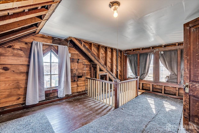 bonus room featuring wooden walls, lofted ceiling, and wood-type flooring