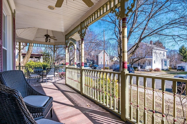 wooden deck with covered porch, a residential view, and ceiling fan