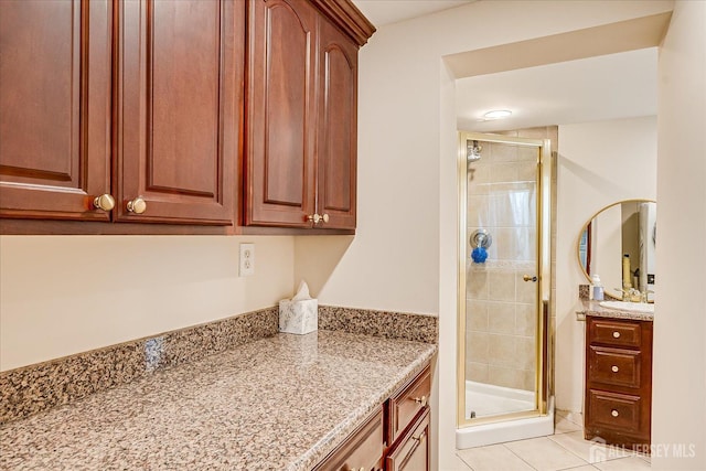 bathroom with tile patterned floors, a stall shower, and vanity