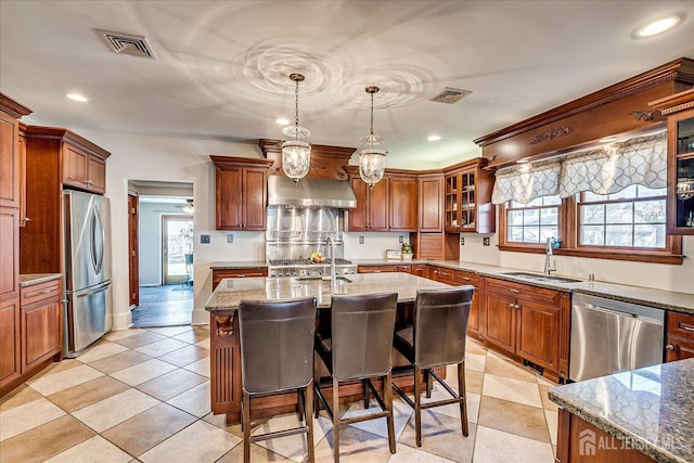 kitchen with visible vents, light stone countertops, stainless steel appliances, and a sink